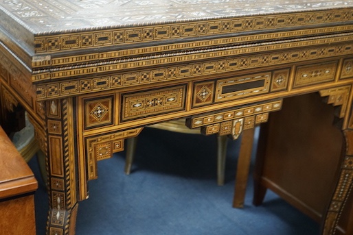 A 19th century Damascus mother of pearl, bone, and marquetry inlaid folding games table, with card, backgammon and chess surfaces, width 94cm, depth 47cm, height 85cm